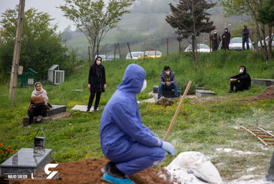 فرزندان یک قربانی کووید-19 در مراسم تشییع پیکر پدرشان طبق پروتکل‌های بهداشتی با فاصله ایستاده‌اند ، روستای اسکارد - مازندران